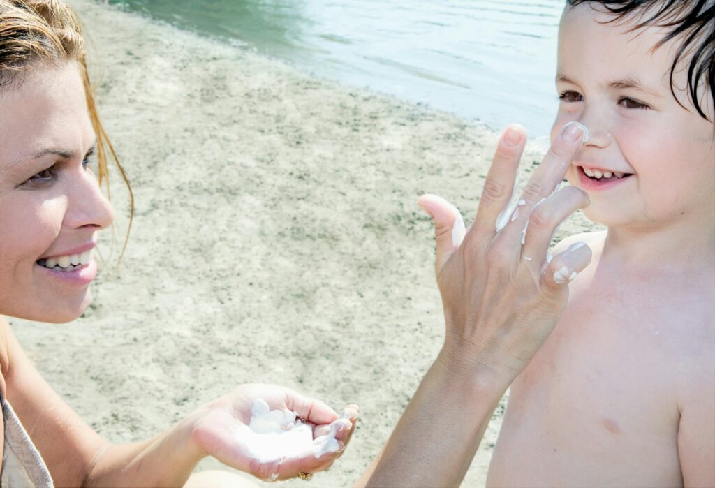 Mother applying sun lotion on Child