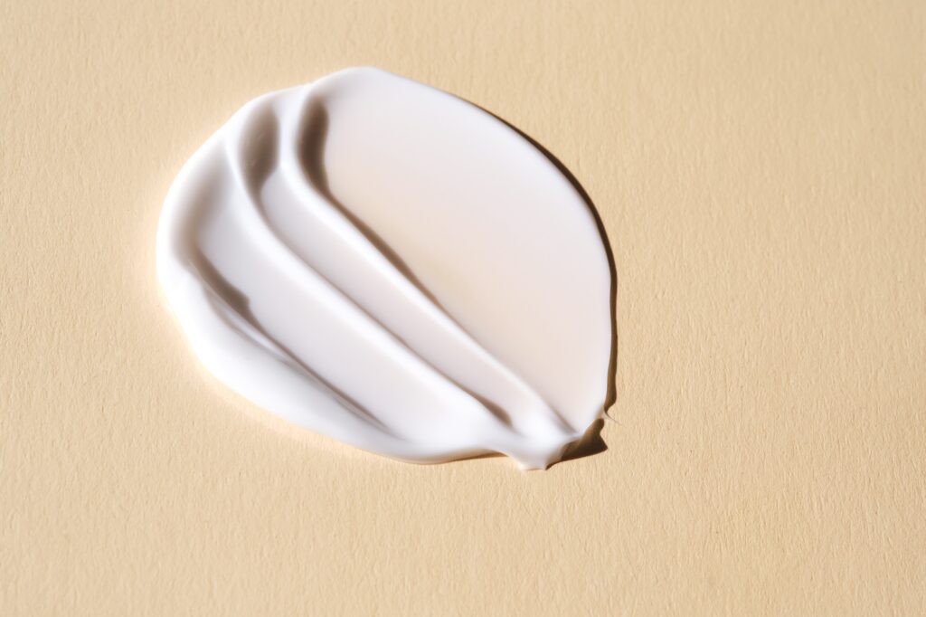 A smear of white cream on a beige background.